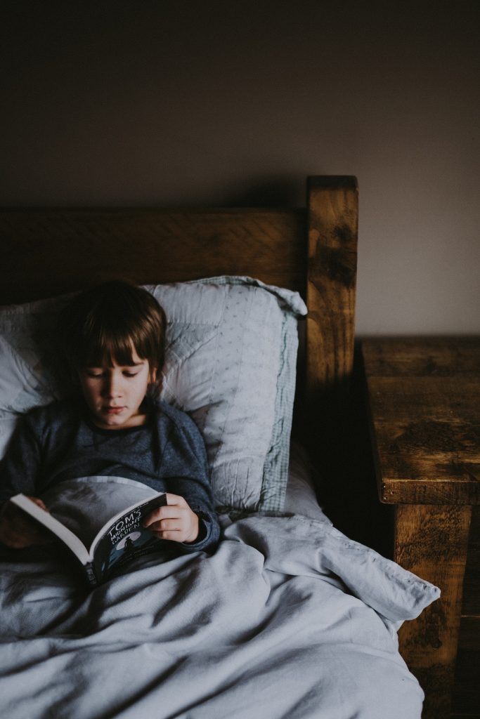 child reading in bed before sleeping